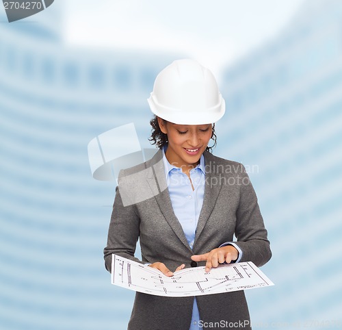 Image of businesswoman in white helmet with blueprint