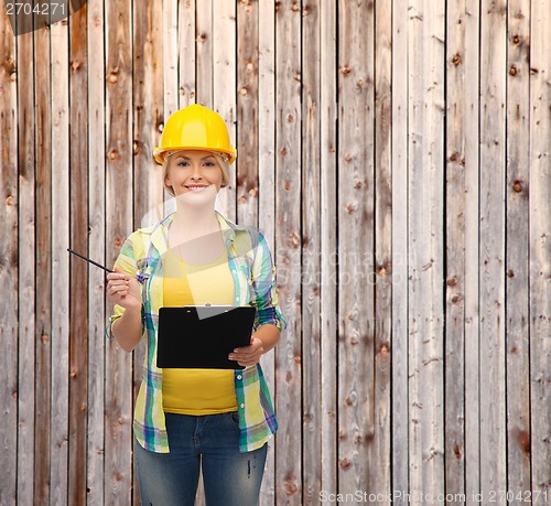 Image of smiling woman in helmet with clipboard