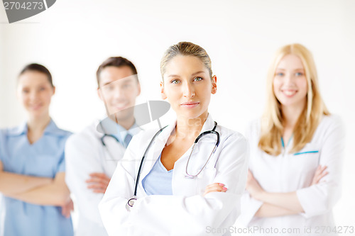 Image of serious female doctor in front of medical group