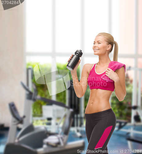 Image of sporty woman drinking water from sportsman bottle