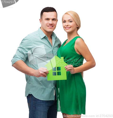 Image of smiling couple holding green paper house