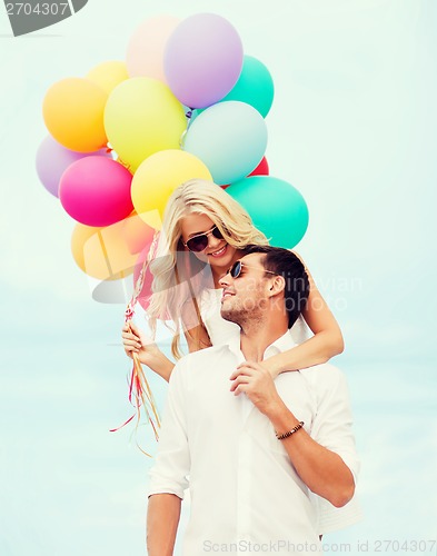 Image of couple with colorful balloons at seaside