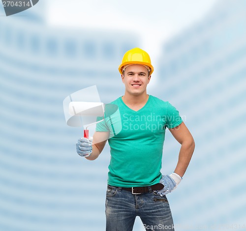 Image of smiling manual worker in helmet with paint roller