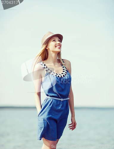 Image of girl in hat walking on the beach