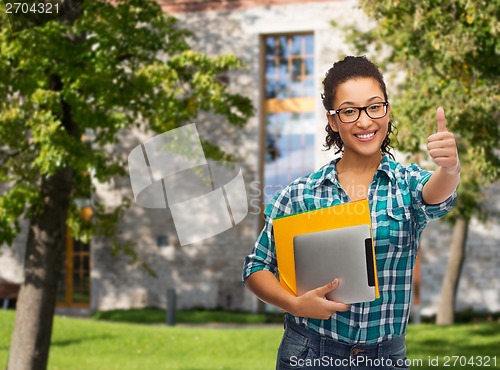 Image of student in eyeglasses with folders and tablet pc