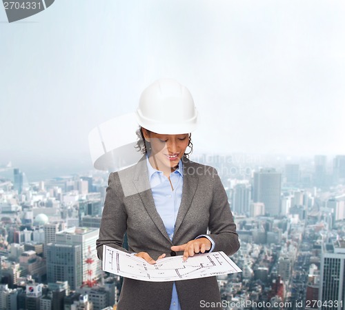 Image of businesswoman in white helmet with blueprint