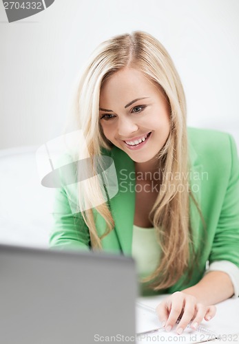 Image of businesswoman with laptop in office