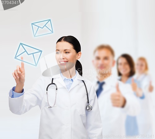 Image of smiling female doctor pointing to envelope