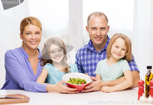 Image of happy family with two kids with salad at home