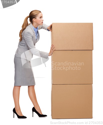 Image of busy businesswoman pushing tower of cardboards