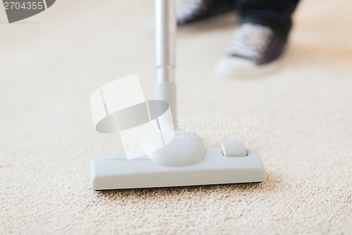 Image of close up of male hoovering carpet