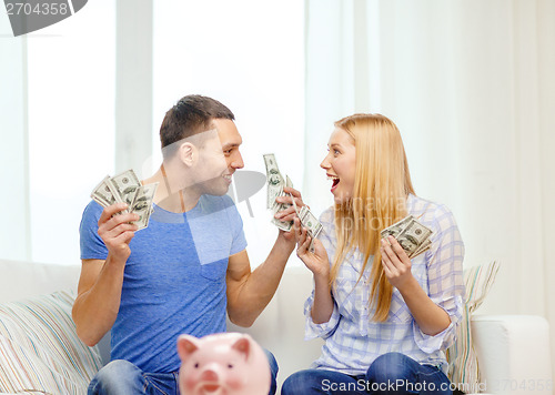 Image of couple with money and piggybank ot table at home