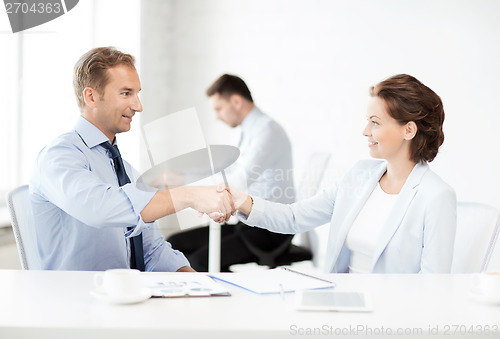 Image of man and woman shaking hands in office