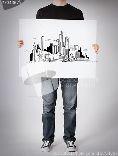 Image of man showing white board with city sketch