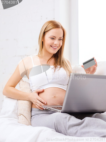 Image of smiling pregnant woman with laptop computer