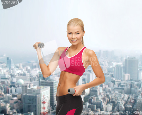 Image of young sporty woman with light dumbbells