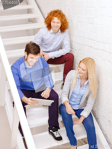 Image of team with tablet pc computer sitting on staircase
