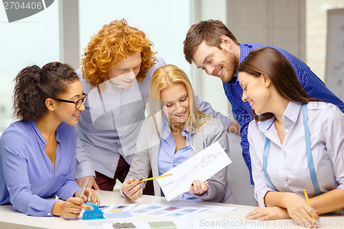 Image of smiling creative team looking at sketch