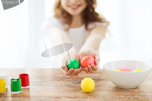 Image of close up of girl holding colored eggs