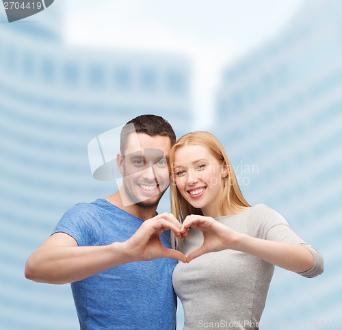 Image of smiling couple showing heart with hands