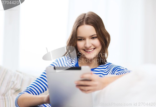 Image of smiling teenage girl with tablet pc at home