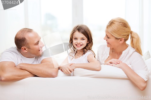 Image of smiling parents and little girl at home