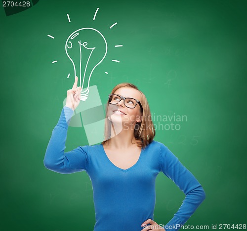 Image of smiling woman pointing her finger up