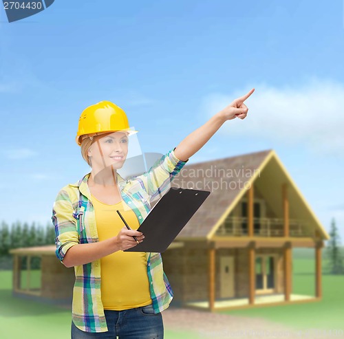 Image of smiling woman in helmet with clipboard