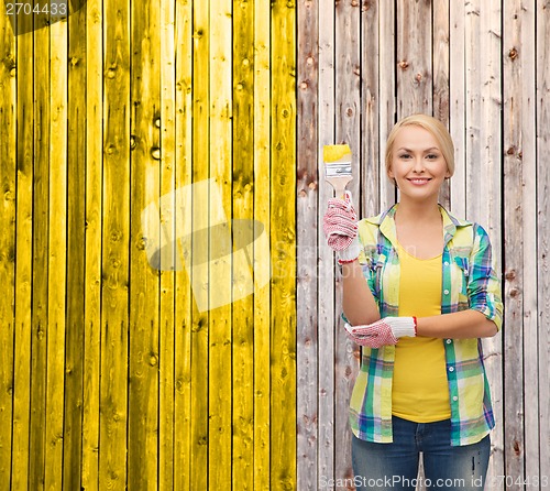 Image of smiling woman with paintbrush