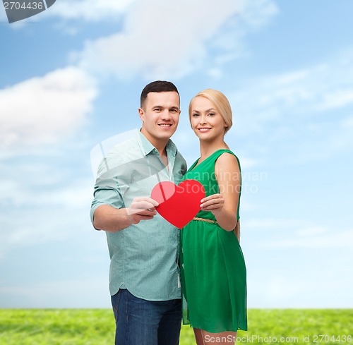 Image of smiling couple holding big red heart