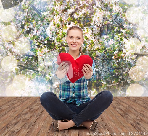 Image of young woman in casual clothes sitting on floor