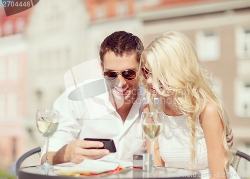 Image of couple looking at smartphone in cafe