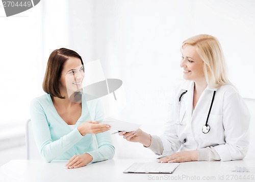 Image of doctor giving prescription to patient in hospital