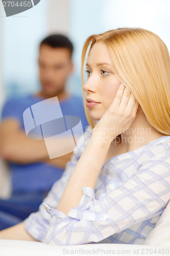 Image of upset young woman with man on the back at home