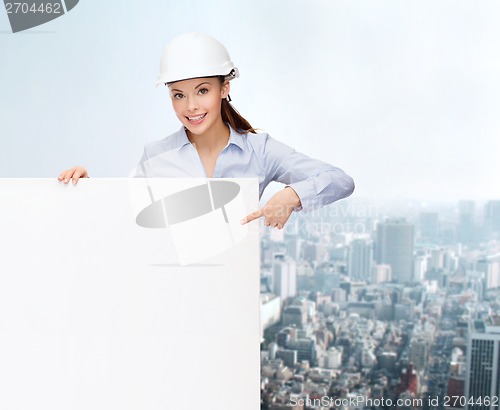 Image of businesswoman in helmet pointing finger to board