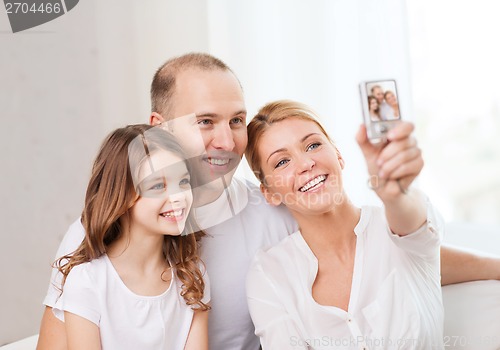 Image of happy family with little girl making self portrait