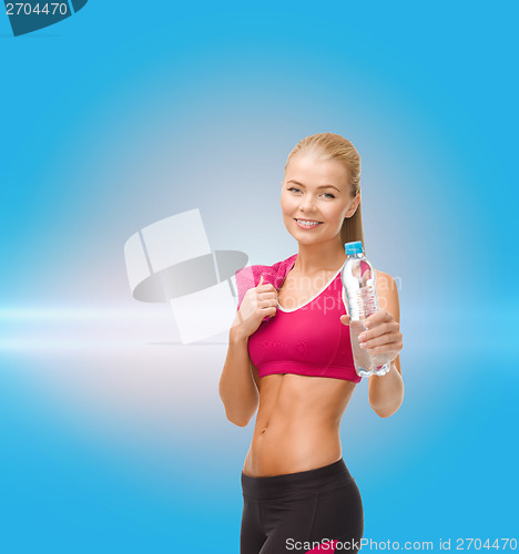 Image of sporty woman with bottle of water and towel