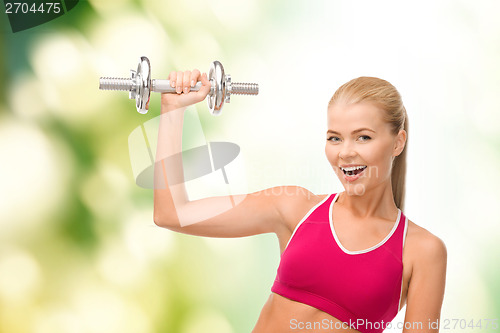 Image of smiling woman with heavy steel dumbbell