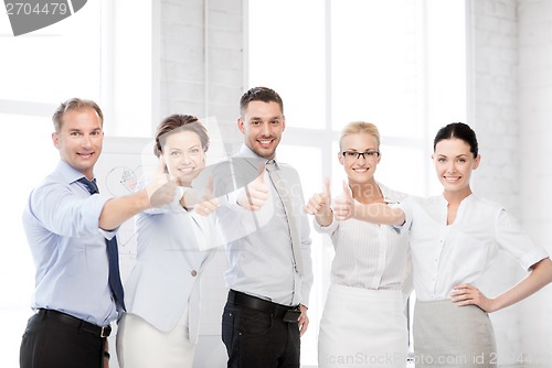 Image of business team showing thumbs up in office