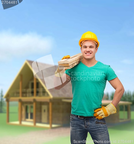 Image of smiling manual worker in helmet with wooden boards