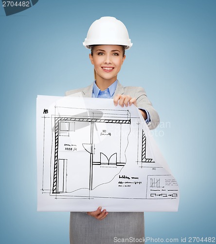 Image of smiling architect in white helmet with blueprints