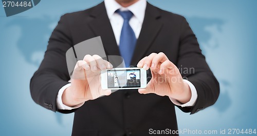 Image of businessman with smartphone and news on screen