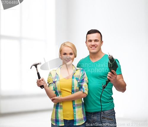 Image of smiling couple with hammer and drill