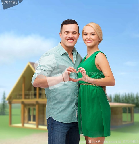 Image of smiling couple showing heart with hands