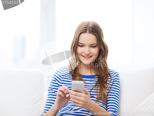 Image of smiling teenage girl with smartphone at home