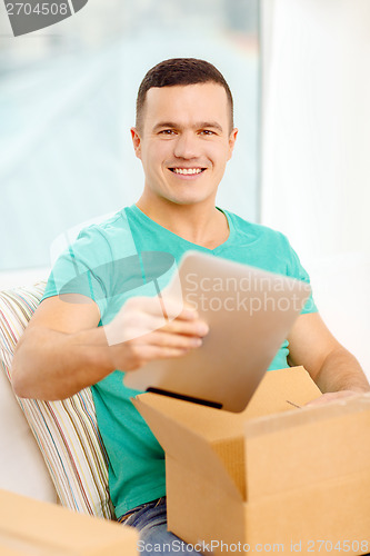 Image of opening cardboard box and taking out tablet pc