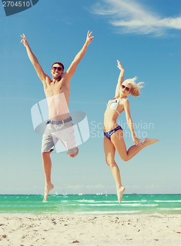 Image of couple jumping on the beach