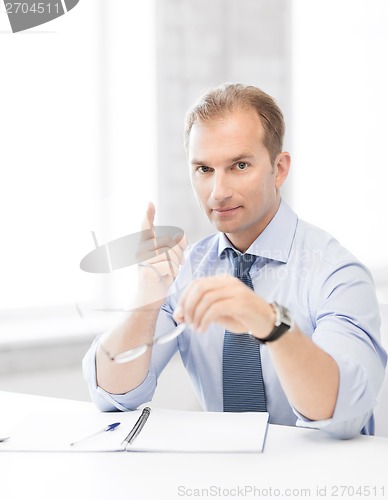 Image of businessman with glasses showing warning gesture