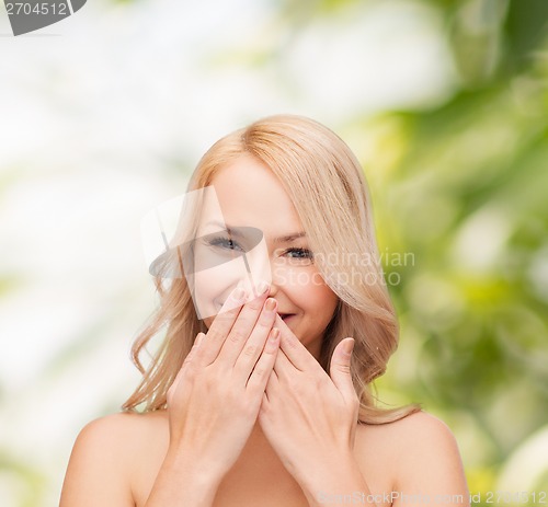 Image of beautiful woman covering her mouth