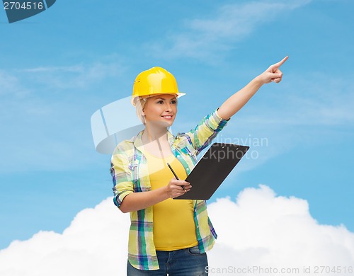 Image of smiling woman in helmet with clipboard